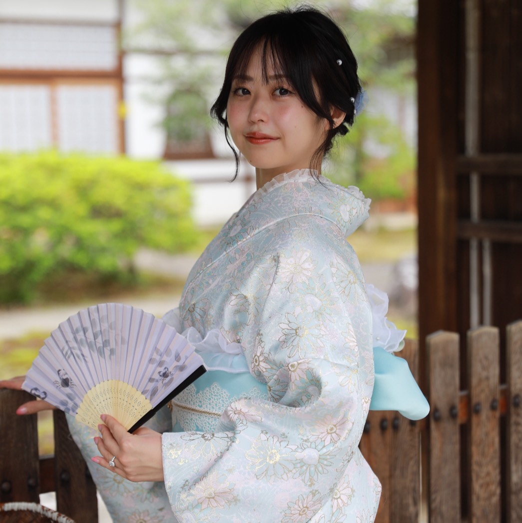 水色の着物姿で扇子を持つ、社長室長のスタッフ